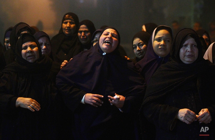 Relatives of 22 year-old journalist Mayada Ashraf, who was killed during clashes between Egyptian police and Muslim Brotherhood supporters, mourn during her funeral in El-Monofiya, north of Cairo, Egypt, Saturday, March 29, 2014. Ashraf, who worked for the privately owned El-Dustour newspaper, was one of four people killed during clashes between security forces and hundreds of supporters of ousted Egyptian president Mohammed Morsi who took to the streets Friday to protest the decision by the country's former military chief to run in upcoming presidential elections. (AP Photo/Ahmed Gomaa)