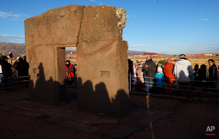People's shadows are cast on the "Door of the Sun" at the ruins of the ancient civilization of Tiwanaku during a new years ritual in the highlands in Tiwanaku, Bolivia, early Saturday, June 21, 2014. The door is believed to be part of an old solar calendar. Bolivia's Aymara Indians are celebrating the year 5,522 as well as the Southern Hemisphere's winter solstice, which marks the start of a new agricultural cycle. (AP Photo/Juan Karita)