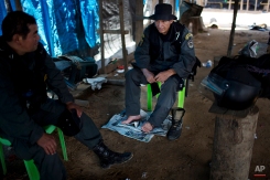 In this Nov. 11, 2014 photo, policemen rest in an illegal gold mining camp they occupied in an operation to eradicate illegal mining in the area known as La Pampa, in Peru's Madre de Dios region. Peru’s anti-illegal mining czar, retired army Gen. Augusto Soto, marched his men to the wasteland known as La Pampa, where 50,000 hectares of rainforest have been obliterated in the past six years. In addition to contributing to deforestation, the illegal alluvial gold mining contaminates the jungle with tons of mercury.(AP Photo/Rodrigo Abd)