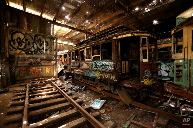 In this Oct. 22, 2014 photo, old tramcars and trolley buses sit abandoned and wrecked in the Loftus Tram Shed in Sydney. Trams became a key part of life in Sydney after the network was installed in 1879, with 1,600 cars in service during the height of its popularity. The service was eventually shut down in 1961. (AP Photo/Rob Griffith)