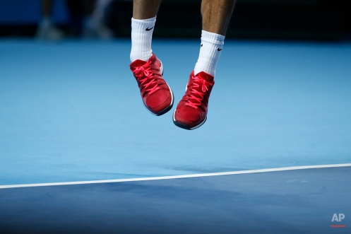 Switzerland’s Roger Federer jumps for a serve to Japan’s Kei Nishikori during their singles ATP World Tour tennis finals match at the O2 arena in London, Tuesday, Nov. 11, 2014. (AP Photo/Alastair Grant)