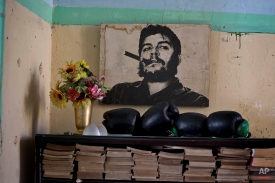 An old photo of Che Guevara hangs on a wall next to several boxing gloves and books in Havana, Cuba, Thursday, Dec. 18, 2014. The United States and Cuba have agreed to establish diplomatic relations and open economic and travel ties, marking the most significant shift in U.S. policy toward the communist island in decades, American officials said Wednesday. (AP Photo/Ramon Espinosa)