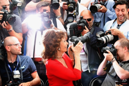 Actress Sophia Loren, front center, takes a photo as she sits with photographers during a photo call for Human Voice (Voce Umana) at the 67th international film festival, Cannes, southern France, Wednesday, May 21, 2014. (AP Photo/Alastair Grant)