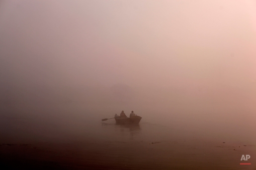 A man rows his boat on the River Ganges in the early morning fog on the outskirts of Allahabad, India, Wednesday, Dec. 3, 2014. Several parts of north India continue to experience cold weather conditions, according to local news reports. (AP Photo/Rajesh Kumar Singh)