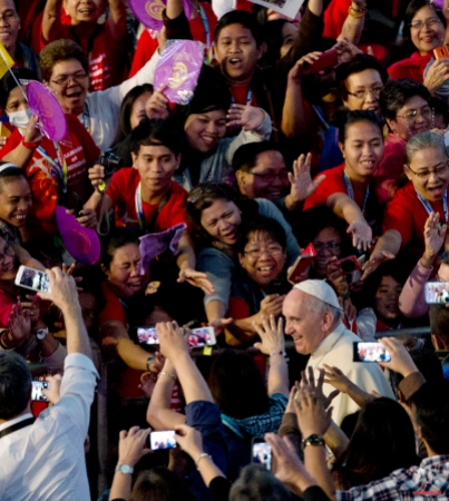 Pope Francis smiles as he arrives at the Mall of Asia arena, in Manila, Philippines, for a meeting with families, on Friday, Jan. 16, 2015. Walking into a packed 20,000-seat arena, Francis greeted and blessed the people who lined his long way to the stage. (AP Photo/Alessandra Tarantino)