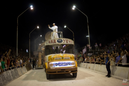 Roman Figun, a local lawyer, performs the role of Pope Francis with the Ara Yevi samba school as he stands on a bus representing his humble arrival to the Vatican during carnival celebrations in Gualeguaychu, Argentina, early Sunday, Jan. 11, 2015. Ara Yevi, one of the three samba schools performing this year, used Pope Francis as their central theme. Figun says he does his best to play the Pope and his carnival group wants to spread his message. (AP Photo/Natacha Pisarenko)
