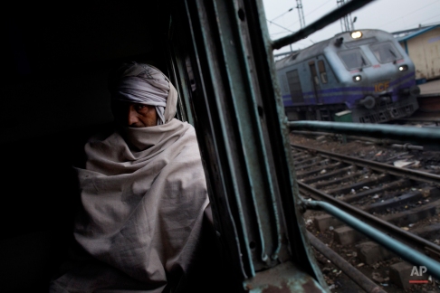 An elderly Indian man sits inside a local train in New Delhi, India, Wednesday, Feb. 25, 2015. India on Thursday is expected to table the 2015 budget for the national railways system, which is one of the world's largest and serves more than 23 million passengers a day. (AP Photo/Bernat Armangue)