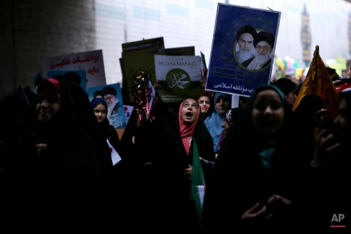 Iranians chant slogans during a rally commemorating the 36th anniversary of Islamic Revolution under Azadi Tower, Tehran, Iran, Wednesday, Feb. 11, 2015. Iran marked the anniversary of its 1979 Islamic Revolution on Wednesday with massive rallies, with many chanting against the U.S. and Israel as the country tries to reach a permanent deal with world powers over its contested nuclear program. (AP Photo/Ebrahim Noroozi)