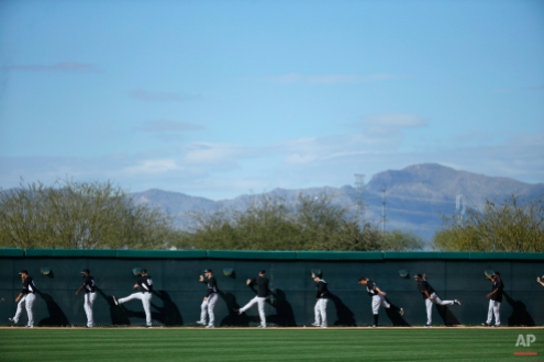 Chicago White Sox players warm up before a spring training baseball workout Tuesday, Feb. 24, 2015, in Phoenix. (AP Photo/John Locher)
