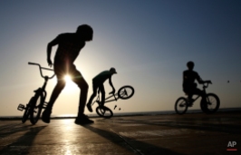Cyclists perform a stunt by the shores of the Arabian Sea in Mumbai, India, Thursday, Feb 19, 2015. (AP Photo/Rafiq Maqbool)