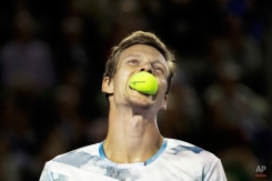 Tomas Berdych of the Czech Republic bites a ball during his semifinal match against Andy Murray of Britain at the Australian Open tennis championship in Melbourne, Australia, Thursday, Jan. 29, 2015. (AP Photo/Bernat Armangue)