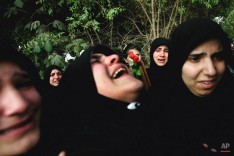 People watch as a Lebanese mourner bursts into tears during a mass funeral procession for twenty nine Lebanese victims of a July 30 Israeli forces' attack, in the southern village of Qana, Lebanon, Friday Aug. 18, 2006. (AP Photo/Lefteris Pitarakis)