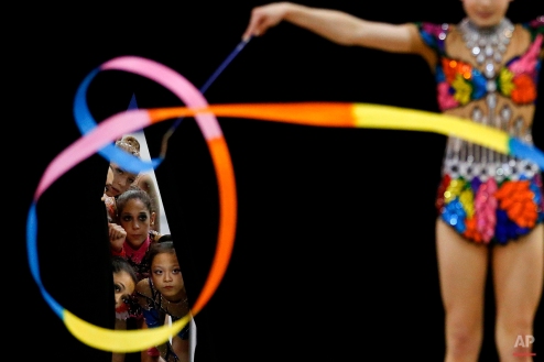 Members of the junior national team watch Jazzy Kerber, foreground, compete during the rhythmic all-around finals at the USA Gymnastics Championships in San Jose, Calif., June 27, 2012. (AP Photo/Jae C. Hong)