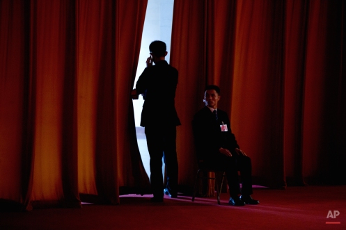 A plainclothes soldier watches the entrance to a curtained-off area during the the opening session of the Chinese People's Political Consultative Conference at the Great Hall of the People in Beijing Tuesday, March 3, 2015. The more than 2,000 members of China's top legislative advisory body convened their annual meeting Tuesday, kicking off a political high season that will continue with the opening of the national congress later in the week. (AP Photo/Mark Schiefelbein)