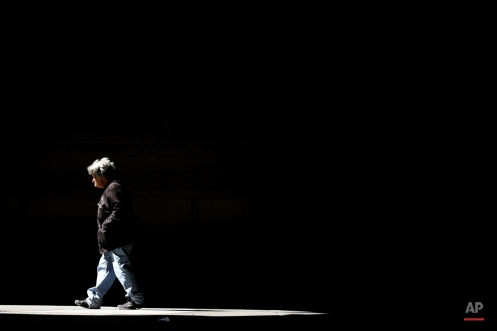 A pedestrian passes into the light from beneath City Hall, Thursday, March 19, 2015, in Philadelphia. (AP Photo/Matt Rourke)