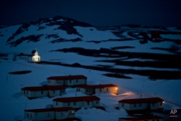 In this Jan. 20, 2015 photo, a church is lit in the town of Villa Las Estrellas on King George Island, Antarctica. Geologists are entranced by Antarctica's secrets. Clues to answering humanity's most basic questions are locked in this continental freezer the size of the United States and half of Canada: Where did we come from? Are we alone in the universe? What's the fate of our warming planet? (AP Photo/Natacha Pisarenko)