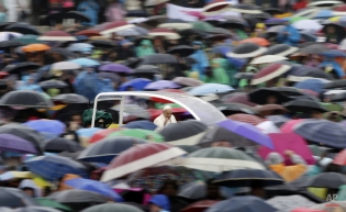 Pope Francis is driven to the crowd under pouring rain as he arrives for his weekly general audience in St. Peter's Square at the Vatican, Wednesday, March 25, 2015. (AP Photo/Andrew Medichini)