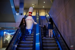 A person dressed as a bowling pin rides an escalator on Jan. 27, 2015, in Los Angeles. (AP Photo/Jae C. Hong)