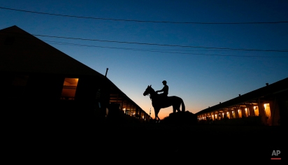 A rider and horse head to the track for an early morning workout at Churchill Downs, Monday, April 27, 2015, in Louisville, Ky. (AP Photo/Charlie Riedel)