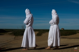 Penitents take part in "La Carrera" procession by the 'Vera Cruz' brotherhood in Villarrin de Campos, Spain, Thursday, April 2, 2015. Hundreds of processions take place throughout Spain during the Easter Holy Week. (AP Photo/Andres Kudacki)