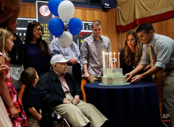 Baseball Hall of Famer Yogi Berra, seated center, looks on as grandson Larry Berra, right, and daughter Lindsay Berra, second right, present him with a birthday cake during his 90th birthday celebration at the Yogi Berra Museum & Learning Center on the campus of Montclair State University Tuesday, May 12, 2015, in Montclair, N.J. (AP Photo/Mel Evans)