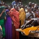 Women in the crowd cover their faces to protect against the smell as authorities display the bodies of the alleged attackers before about 2,000 people in a large open area in central Garissa, Kenya, Saturday, April 4, 2015. Authorities displayed the bodies of the alleged attackers involved in the killings at Garissa University College on the bed of a pickup truck that drove slowly past the crowd, which broke into a run in pursuit. (AP Photo/Ben Curtis)