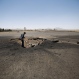 A Yemeni man looks at a crater, at the Sanaa International airport, in Yemen, Wednesday, April 29, 2015. Saudi-led coalition warplanes pounded Shiite rebels and their allies overnight and throughout the day on Tuesday in the Yemeni capital. Around midday, airstrikes hit Sanaa International airport, setting a plane owned by a private company on fire, according to a statement released by the Shiite rebels, known as Houthis. (AP Photo/Hani Mohammed)