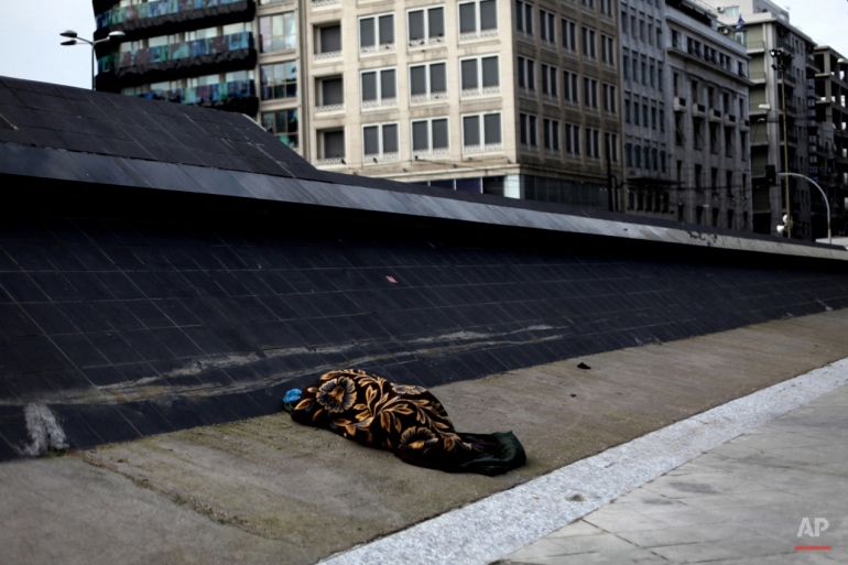In this Feb. 23, 2012 photo, a homeless person sleeps at Omonoia square in central Athens on Thursday, Feb. 23, 2012. (AP Photo/Petros Giannakouris)