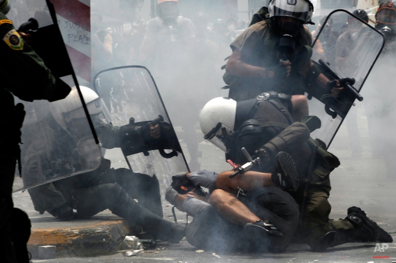 In this June 29, 2011 photo, riot policemen arrest a protester during clashes in central Athens. (AP Photo/Petros Giannakouris)