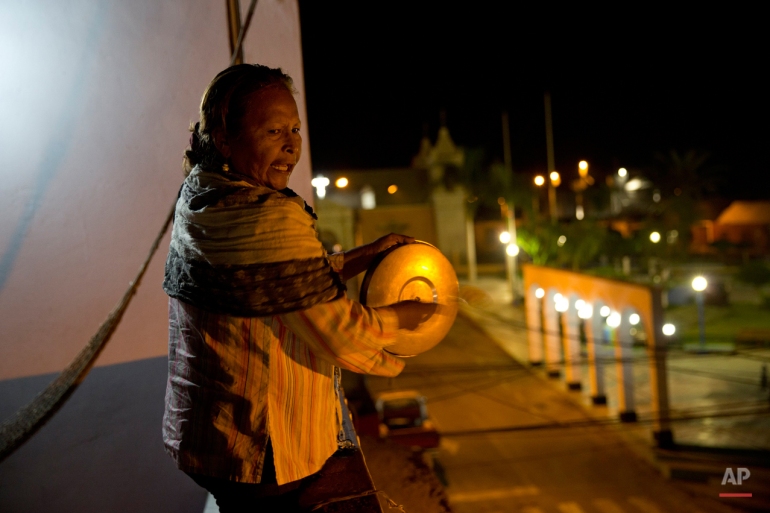 In this May 29, 2015 photo, Abigail Torres clangs on the lid of a pot to protest the 60-day martial law in Tambo Valley, Arequipa, Peru. The Peruvian government imposed martial law after nearly two months of violent anti-mining protests in which four with killed and more than 350 people injured. (AP Photo/Rodrigo Abd)