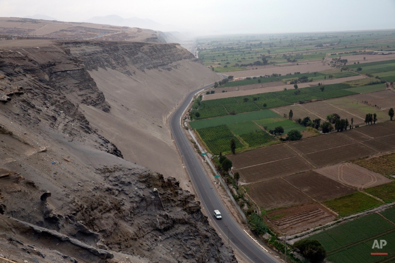 In this May 29, 2015 photo, a van drives on the Costanera Norte road, connecting Punta Bombon and Dean Valdivia, in the Tambo Valley, Arequipa, Peru. The road is sandwiched between the rich farmland of the valley and the poorer desert zone known as Pueblo Jovenes. (AP Photo/Rodrigo Abd)