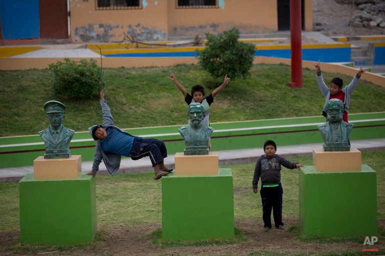 In this May 30, 2015 photo, children playfully climb on busts of Peruvian national heroes, Jose Abelardo Quinonez Boqueron, from left, Francisco Bolognesi, and Miguel Grau, in the main square of Dean Valdivia, in the Tambo Valley, Arequipa, Peru. The government suspended civil liberties after nearly two months of violent anti-mining protests to prevent the mining company, Grupo Mexico, from implementing a copper mining project that they feared would pollute the the area. (AP Photo/Rodrigo Abd)