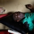 A demonstrator seriously wounded by live ammunition waits for treatment in a small clinic in the Musaga district of Bujumbura, Burundi, Monday, May 4, 2015. Anti-government demonstrations resumed in Burundi's capital after a weekend pause as thousands continue to protest the president's decision to seek a third term. (AP Photo/Jerome Delay)