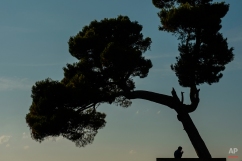 A man smokes a cigarette under a tree during the evening of a summer day, in Pamplona, northern Spain, Wednesday, Aug. 5, 2015. (AP Photo/Alvaro Barrientos)
