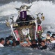 Participants carry a portable shrine, or mikoshi, into the sea during a purification rite at the annual Hamaori Festival in Chigasaki, west of Tokyo early Monday, July 20, 2015. The festival originated from an old times' story about a shrine that was washed away by flood and later found by fishermen. (AP Photo/Koji Sasahara)