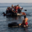 Two migrants pull an overcrowded dinghy with Syrian and Afghan refugees arriving from the Turkish coasts to the Greek island of Lesbos, Monday, July 27, 2015. Nearly 50,000 people have illegally entered the country this year, mostly Syrian refugees who risk the sea crossing from Turkey in dangerous, overcrowded boats. From Greece, most try to continue north through the Balkans to more affluent European countries such as Germany. (AP Photo/Santi Palacios)