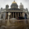 Raindrops fall into a puddle in St.Petersburg, Russia, Tuesday, July 7, 2015, with the city's landmark St. Isaac's Cathedral in the background. Cyclone from the west brought rains to St. Petersburg on Tuesday. (AP Photo/Dmitry Lovetsky)