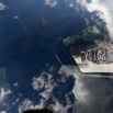 Clouds reflect in a car window as the pack with Britain's Chris Froome, wearing the overall leader's yellow jersey, passes during the nineteenth stage of the Tour de France cycling race over 138 kilometers (85.7 miles) with start in Saint-Jean-de-Maurienne and finish in La Toussuire, France, Friday, July 24, 2015. (AP Photo/Laurent Cipriani)
