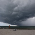 Arnie Powell walks along the beach with his pet dog, Biscuit, as rain clouds approach Hobie Beach, Wednesday, July 22, 2015, in Key Biscayne, Fla. (AP Photo/Alan Diaz)