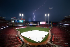 Lightning strikes over northern Kentucky as seen from Great American Ball Park during a rain delay before a baseball game between the Cincinnati Reds and the Milwaukee Brewers, Friday, Sept. 4, 2015, in Cincinnati. (AP Photo/John Minchillo)