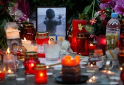 A portrait of 10 month Darina Gromova, a victim of a plane crash, is surrounded by flowers and candles at an entrance of Pulkovo airport outside St. Petersburg, Russia, Monday, Nov. 2, 2015. In a massive outpouring of grief, thousands of people flocked to St. Petersburg's airport, laying flowers, soft toys and paper planes next to the pictures of the victims of the crash of a passenger jet in Egypt that killed all 224 on board in Russia's deadliest air crash to date. (AP Photo/Dmitry Lovetsky)