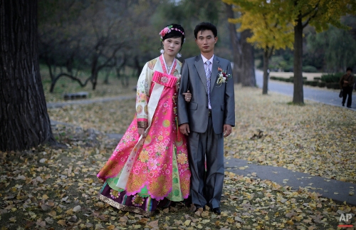 In this photo taken Saturday, Oct. 25, 2014, a North Korean bride and groom pose for a photograph at the Moranbong hill where they went to take wedding pictures, in Pyongyang, North Korea. The couple, Ri Ok Ran, 28 and Kang Sung Jin, 32, were married Saturday after dating for about two years. (AP Photo/Maye-E Wong)
