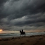 A woman rides a horse along a beach in Cadiz, southern Spain, Monday, Oct. 19, 2015. Spain's weather is turning colder as autumnal storms head for the peninsula from the atlantic ocean. (AP Photo/Emilio Morenatti)
