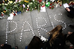 Young women have formed the word Paris with candles to mourn for the victims killed in Friday's attacks in Paris, in front of the French Embassy in Berlin, Saturday, Nov. 14, 2015. (AP Photo/Markus Schreiber)