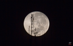 A full moon silhouettes television and radio antennas on Boutilier Mountain, in Port-au-Prince, Haiti, early Sunday, Sept. 27, 2015. (AP Photo/Dieu Nalio Chery)