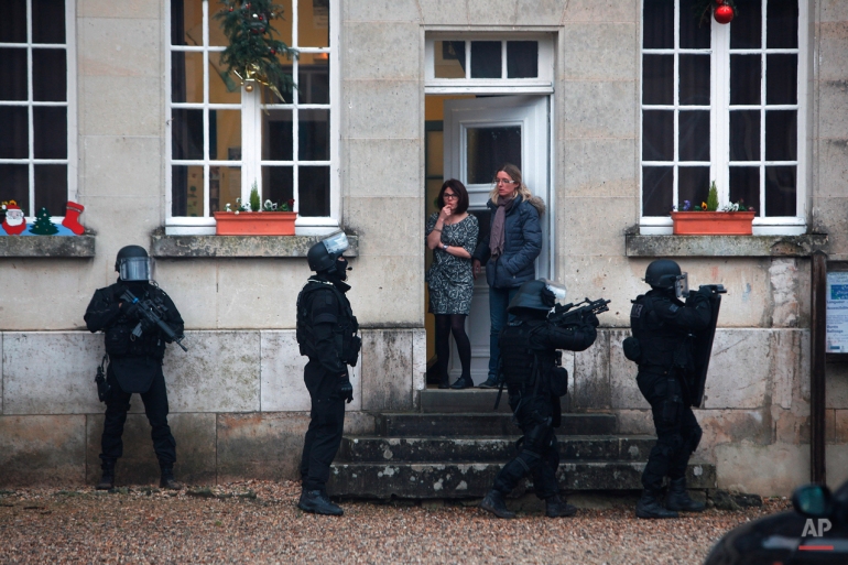 French riot officers patrol in Longpont, north of Paris, Thursday, Jan. 8, 2015. Scattered gunfire and explosions shook the city as its frightened yet defiant citizens held a day of mourning for 12 people slain at the Paris newspaper Charlie Hebdo. French police hunted down the two heavily armed brothers suspected in the massacre. (AP Photo/Thibault Camus)