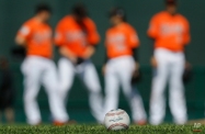 A baseball sits on a field as members of the Baltimore Orioles participate in a spring training baseball workout in Sarasota, Fla., Tuesday, Feb. 23, 2016. (AP Photo/Patrick Semansky)