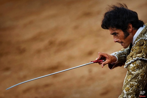 Spanish bullfighter Paulita, aims his sword before killing a bull during the daily afternoon bullfight of the San Fermin festival in Pamplona, Spain, Saturday, July 11, 2015. Revelers from around the world arrive in Pamplona every year to take part on some of the eight days of party and the running of the bulls. (AP Photo/Daniel Ochoa de Olza)