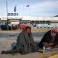 Two men from Iraq sit at a parking area outside the old international airport, which is used as a shelter for refugees and migrants, in southern Athens, Saturday, Feb. 27, 2016. Hastily setup camps for refugees and other migrants are full. Thousands of people wait through the night, shivering in the cold at the Greek-Macedonian border, in the country's main port of Piraeus, in squares dotted around Athens, or on dozens of buses parked up and down Greece's main north-south highway. (AP Photo/ Yorgos Karahalis)