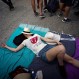 In this March 25, 2016 photo, a fan lies on the floor as she waits outside the venue where the Rolling Stones will play their concert in Havana, Cuba. The Stones are performing in a free concert in Havana Friday, becoming the most famous act to play Cuba since its 1959 revolution. (AP Photo/Ramon Espinosa)